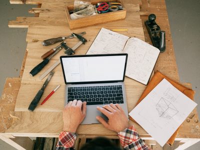 a person using a laptop while on the carpentry workbench