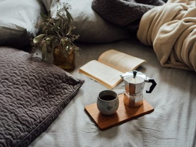 coffee and book on comfortable bed