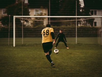 man in black and yellow jersey shirt playing soccer